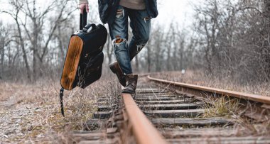 Demiryolunda süet sonbahar botları giyen bir adam. Yürüyüş, seyahat pratik kıyafetler, ayakkabılar..