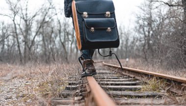 Demiryolunda süet sonbahar botları giyen bir adam. Yürüyüş, seyahat pratik kıyafetler, ayakkabılar..