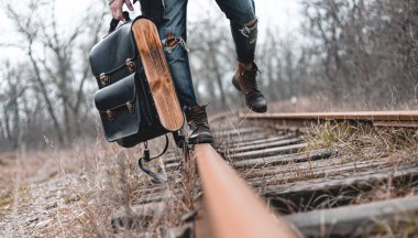 Demiryolunda süet sonbahar botları giyen bir adam. Yürüyüş, seyahat pratik kıyafetler, ayakkabılar..