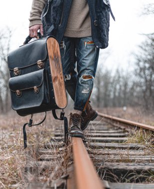 Demiryolunda süet sonbahar botları giyen bir adam. Yürüyüş, seyahat pratik kıyafetler, ayakkabılar..