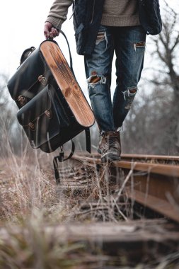 Demiryolunda süet sonbahar botları giyen bir adam. Yürüyüş, seyahat pratik kıyafetler, ayakkabılar..