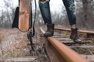 Demiryolunda süet sonbahar botları giyen bir adam. Yürüyüş, seyahat pratik kıyafetler, ayakkabılar..