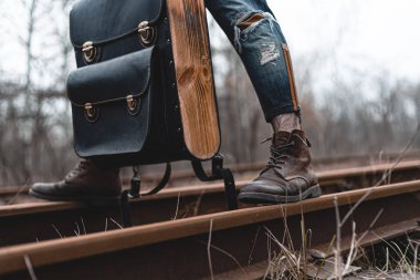 Demiryolunda süet sonbahar botları giyen bir adam. Yürüyüş, seyahat pratik kıyafetler, ayakkabılar..