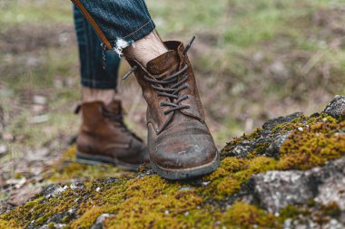Yürüyüş ayakkabısı giymiş rahat bir adam. Botların yakın plan fotoğrafı..
