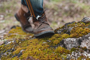 Yürüyüş ayakkabısı giymiş rahat bir adam. Botların yakın plan fotoğrafı..