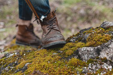 Yürüyüş ayakkabısı giymiş rahat bir adam. Botların yakın plan fotoğrafı..