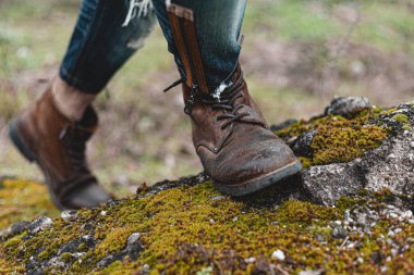 Yürüyüş ayakkabısı giymiş rahat bir adam. Botların yakın plan fotoğrafı..
