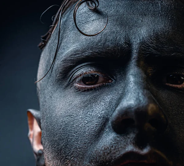 The dirty face of a working miner. Close-up portrait of a black face in soot. Stock photo.