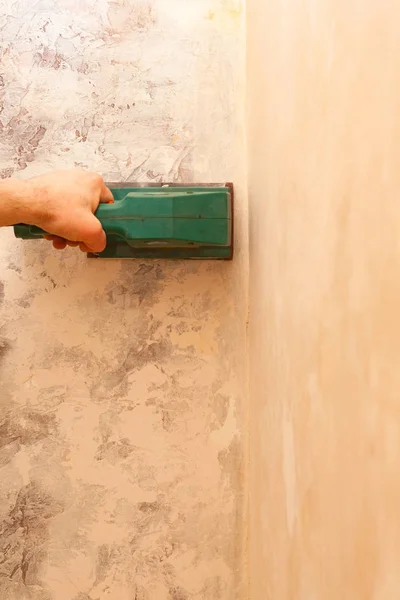 Electronic grinder in a hand. Grinding and leveling the surface of the walls. — Stock Image Electronic Grinder Hand Grinding Leveling Surface Walls Royalty Free Stock Photos
