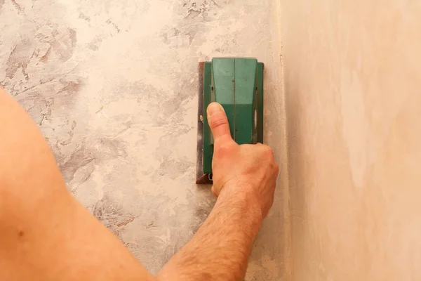 Electronic grinder in a hand. Grinding and leveling the surface of the walls. — Stock Image Electronic Grinder Hand Grinding Leveling Surface Walls Stock Image
