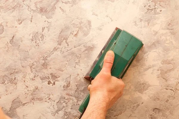 Electronic grinder in a hand. Grinding and leveling the surface of the walls. — Stock Image Electronic Grinder Hand Grinding Leveling Surface Walls Stock Image