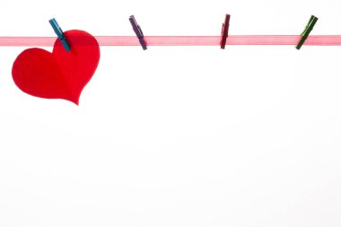 Beyaz arka plandaki mandallarda kırmızı kağıt kalpler. Sevgililer Günü konsepti.