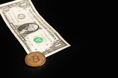 Siyah arka planda dolar banknot ve bitcoin.