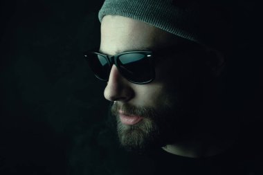 Siyah arka planda beyaz hippi bir sakallının portresi. Stüdyo stok fotoğraf konsepti sigara ve marihuana.