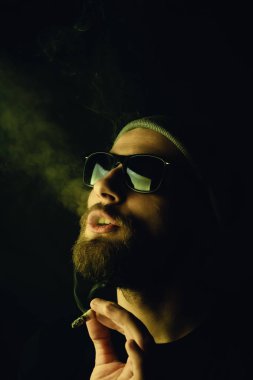 Siyah arka planda beyaz hippi bir sakallının portresi. Stüdyo stok fotoğraf konsepti sigara ve marihuana.