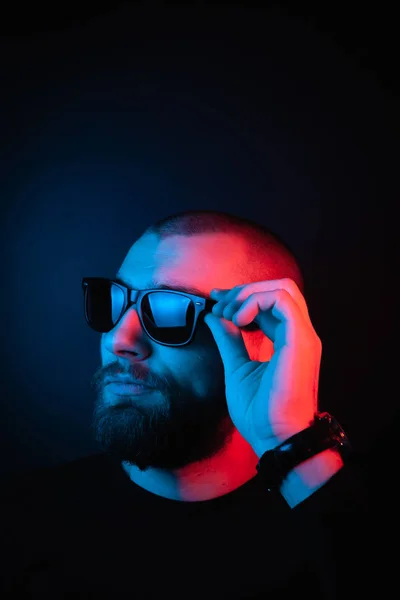 Brutal portrait neon style. Portrait of the face of a charismatic guy with a beard.
