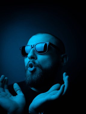 Neon tarzı karizmatik bir adamın stüdyo portresi. Sakallı bir adamın sürpriz fotoğrafı..