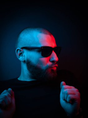 Neon tarzı karizmatik bir adamın stüdyo portresi. Sakallı bir adamın sürpriz fotoğrafı..