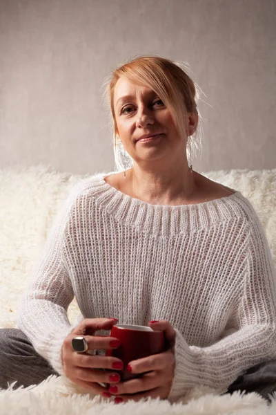 Portret Dorosłej Kobiety Przytulnym Pokoju Kanapie Filiżanką Herbaty Kawy — Zdjęcie stockowe