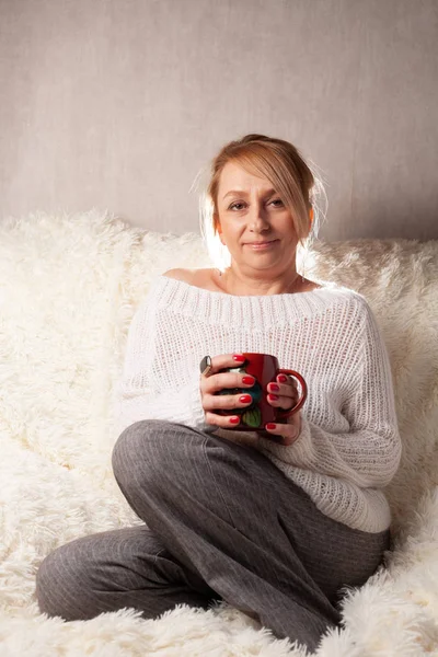 Portret Dorosłej Kobiety Przytulnym Pokoju Kanapie Filiżanką Herbaty Kawy — Zdjęcie stockowe