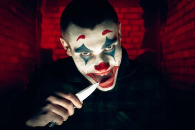 Şakacı bir adamın yakın plan portresi. Dehşet odasında makyaj malzemesi..