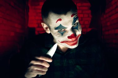 Şakacı bir adamın yakın plan portresi. Dehşet odasında makyaj malzemesi..