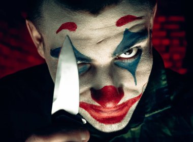 Şakacı bir adamın yakın plan portresi. Dehşet odasında makyaj malzemesi..