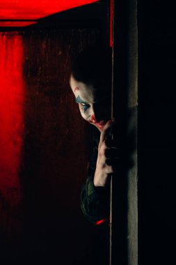 Şakacı bir adamın yakın plan portresi. Dehşet odasında makyaj malzemesi..