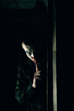 Şakacı bir adamın yakın plan portresi. Dehşet odasında makyaj malzemesi..