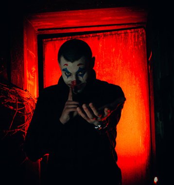 Şakacı bir adamın yakın plan portresi. Dehşet odasında makyaj malzemesi..