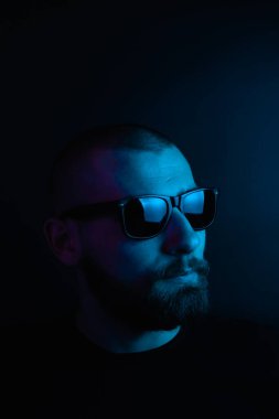 Renkli ışıklı bir hipster portresi. Stüdyoda hippi portresi.