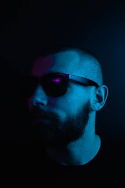 Renkli ışıklı bir hipster portresi. Stüdyoda hippi portresi.