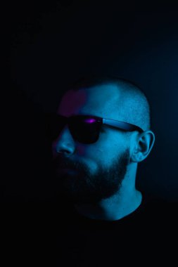 Renkli ışıklı bir hipster portresi. Stüdyoda hippi portresi.