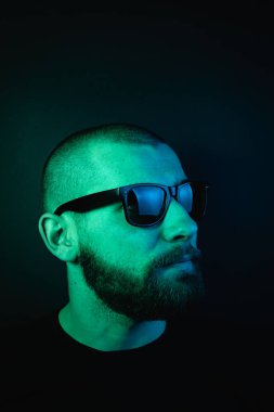 Renkli ışıklı bir hipster portresi. Stüdyoda hippi portresi.