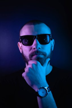 Renkli ışıklı bir hipster portresi. Stüdyoda hippi portresi.