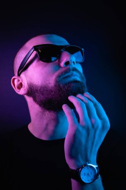Renkli ışıklı bir hipster portresi. Stüdyoda hippi portresi.