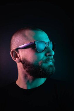 Renkli ışıklı bir hipster portresi. Stüdyoda hippi portresi.