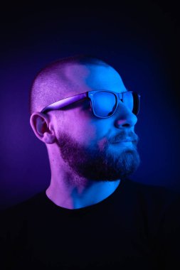 Renkli ışıklı bir hipster portresi. Stüdyoda hippi portresi.