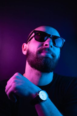 Renkli ışıklı bir hipster portresi. Stüdyoda hippi portresi.