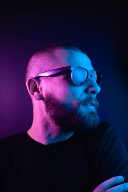 Renkli ışıklı bir hipster portresi. Stüdyoda hippi portresi.