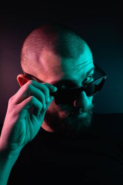 Renkli ışıklı bir hipster portresi. Stüdyoda hippi portresi.