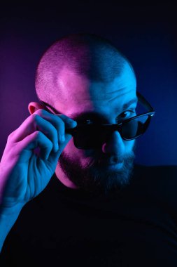 Renkli ışıklı bir hipster portresi. Stüdyoda hippi portresi.