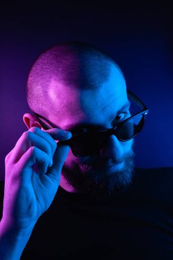 Renkli ışıklı bir hipster portresi. Stüdyoda hippi portresi.