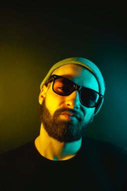 Renkli ışıklı bir hipster portresi. Stüdyoda hippi portresi.