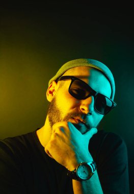 Renkli ışıklı bir hipster portresi. Stüdyoda hippi portresi.