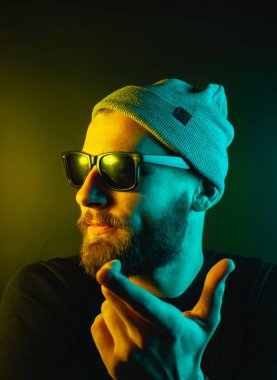 Renkli ışıklı bir hipster portresi. Stüdyoda hippi portresi.