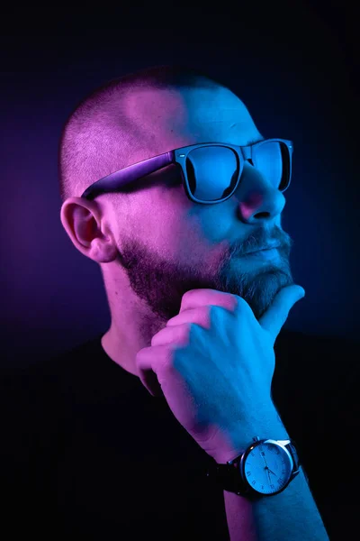 Portrait of a hipster guy with color light. Hipster face portrait in studio.