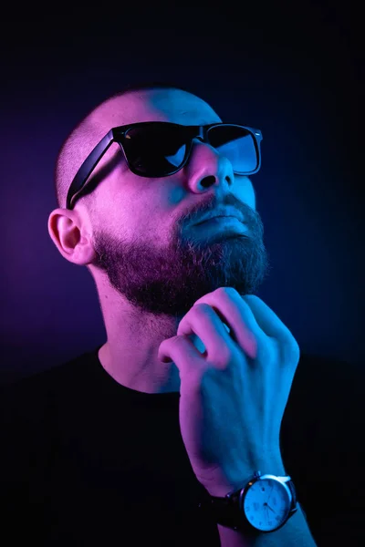 Portrait of a hipster guy with color light. Hipster face portrait in studio.