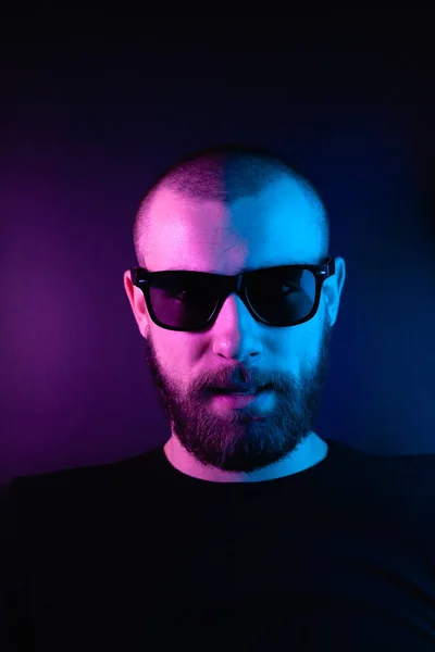 Portrait of a hipster guy with color light. Hipster face portrait in studio.