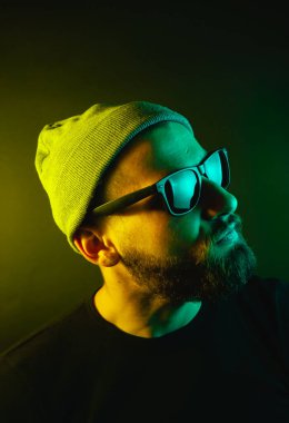 Renkli ışıklı bir hipster portresi. Stüdyoda hippi portresi.